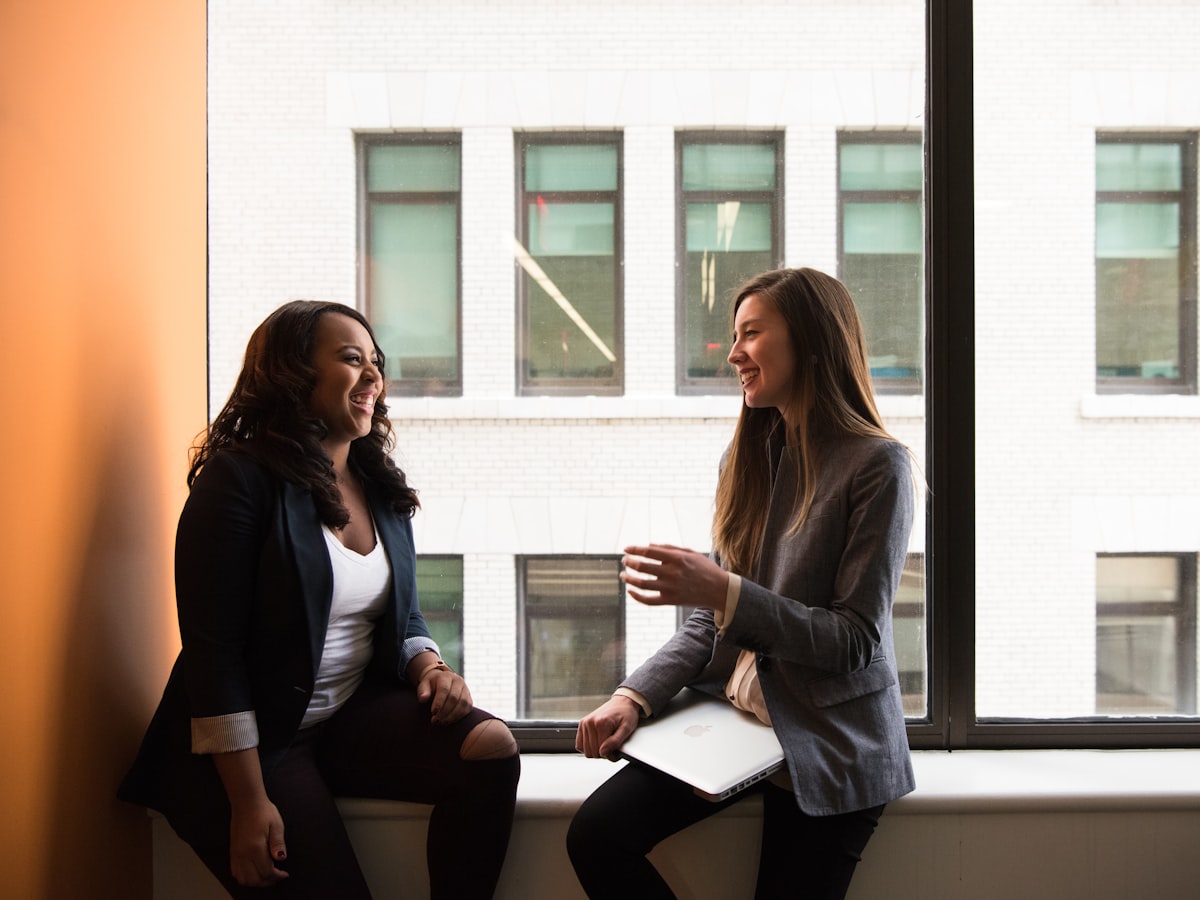 Two colleagues in conversation in a bright office
