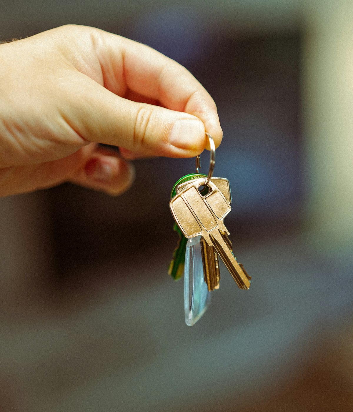 A hand holding a set of house keys